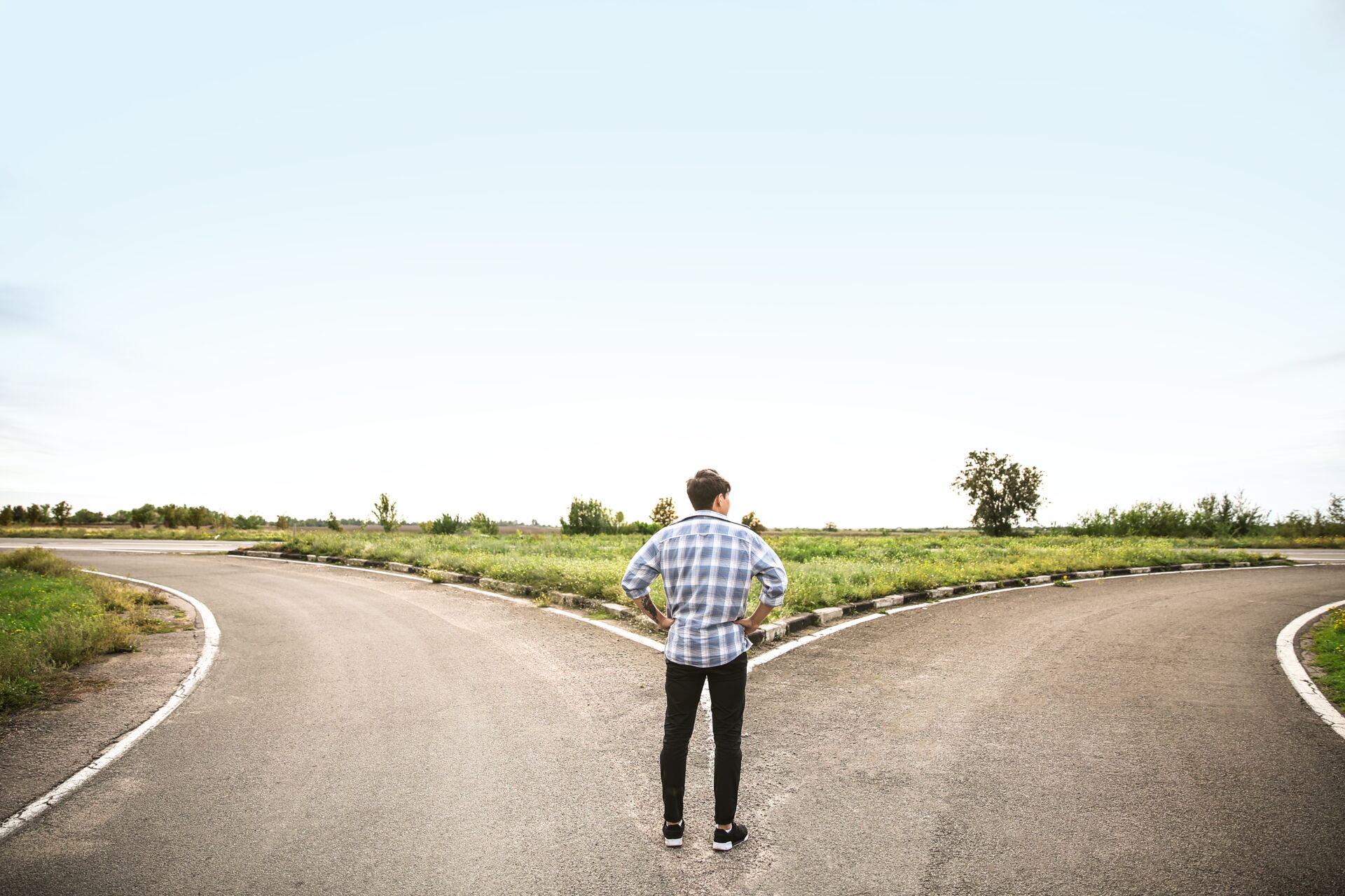 Ein Mann der vor einer Wegkreuzung steht.